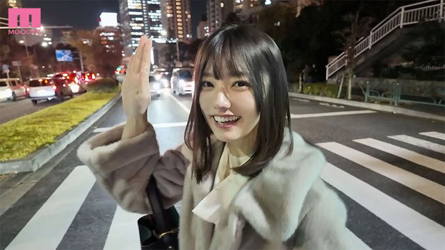 宮下玲奈が夜の道路で片手を上げて笑う