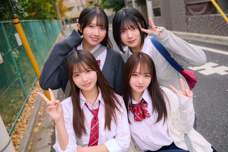 通学路で制服姿の仲良し4人組が集まり、前列2人と後列2人でカメラを見る